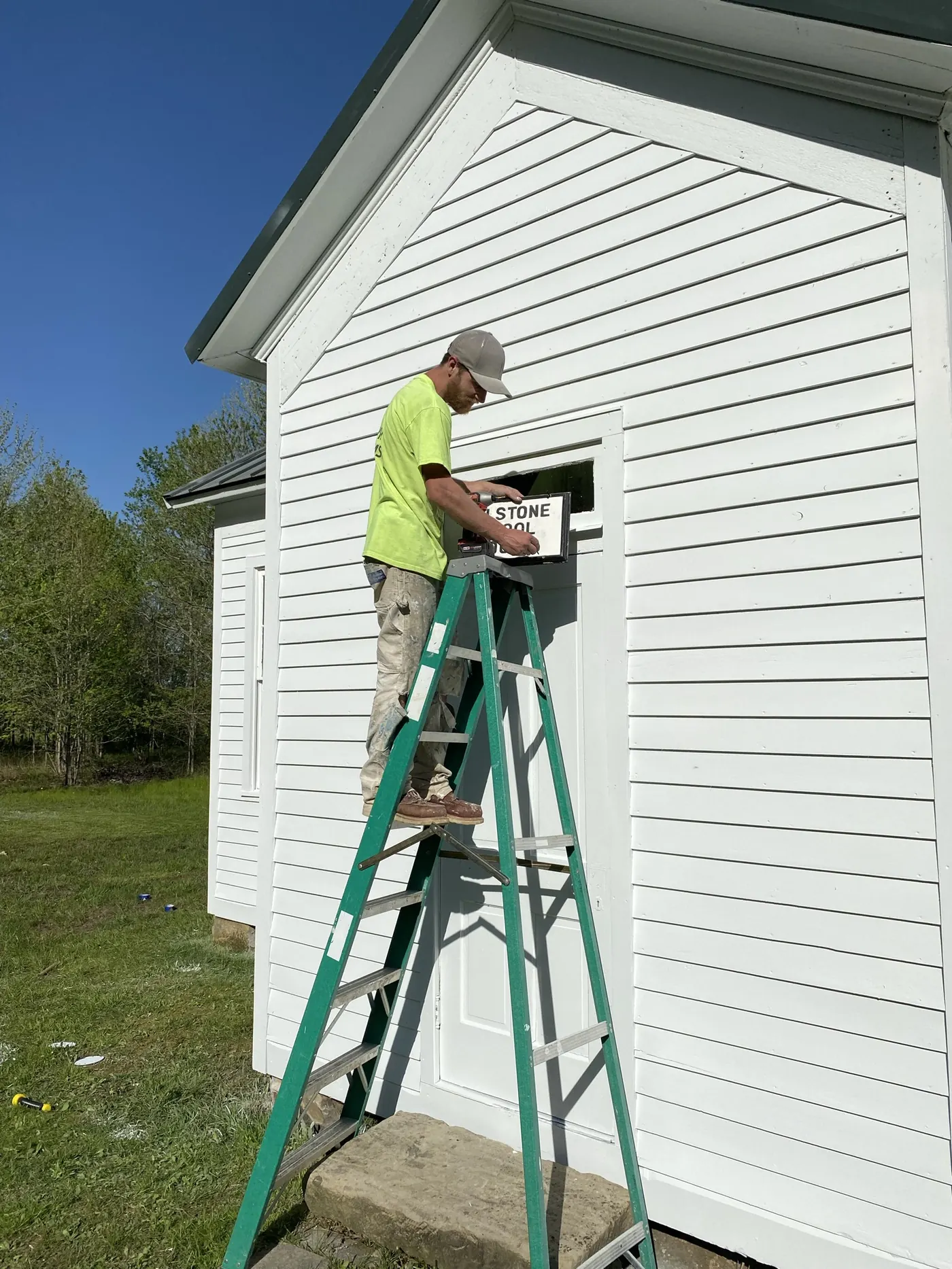 Bebout That Paint painter on a ladder working on white siding